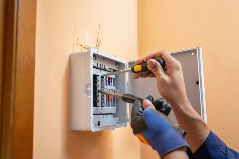 Elektriker prüft Sicherungskasten beim Notfalleinsatz